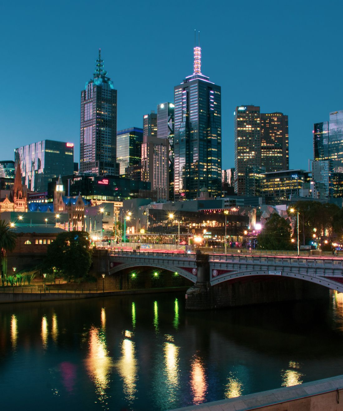 Melbourne city skyline at dusk, with the Yarra River and Princes Bridge.